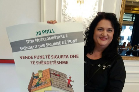 ILO National Coordinator in Albania, Zhulieta Harasani with poster for the Albanian labour inspection campaign